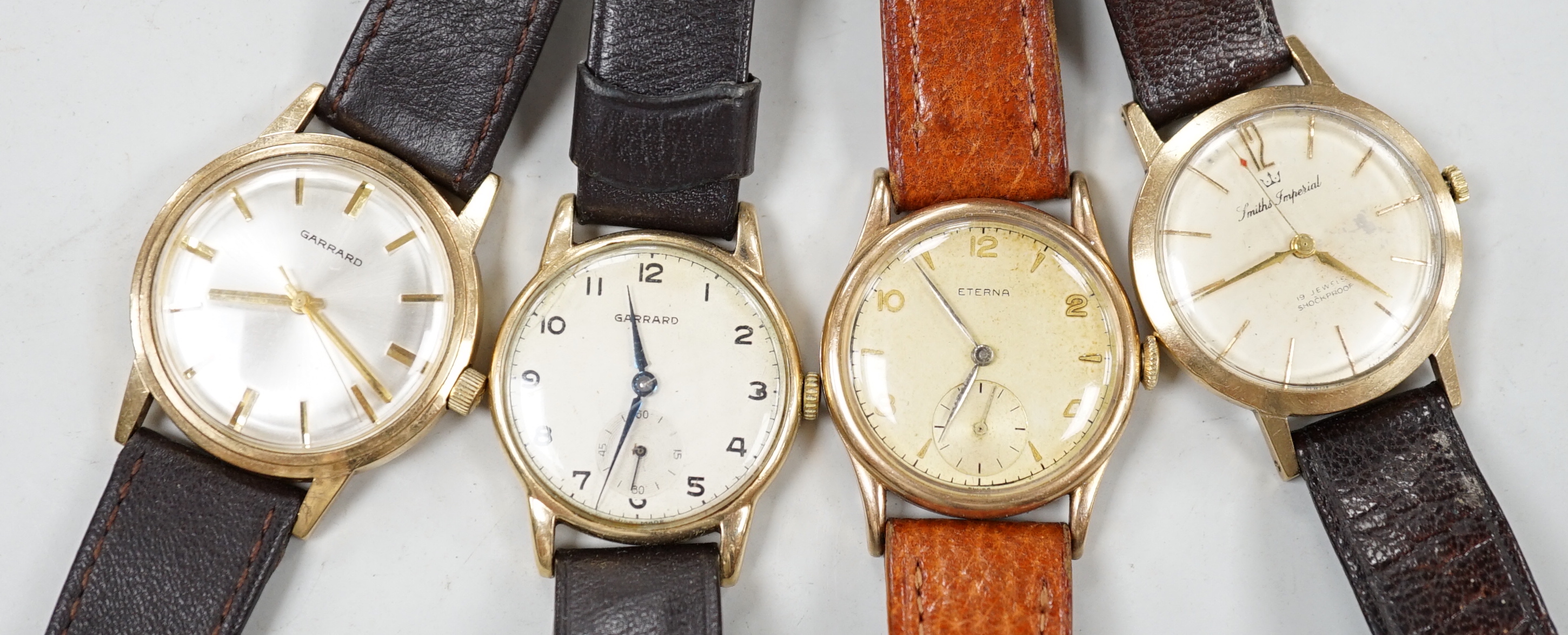 Two gentleman's 9ct gold manual wind wrist watches, retailed by Garrards, both with engraved inscription and two other 9ct gold wrist watches including Eterna.